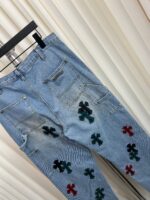 Jeans vintage azzurri con patch a croce colorati, stile casual e urbano, pratici e di tendenza.