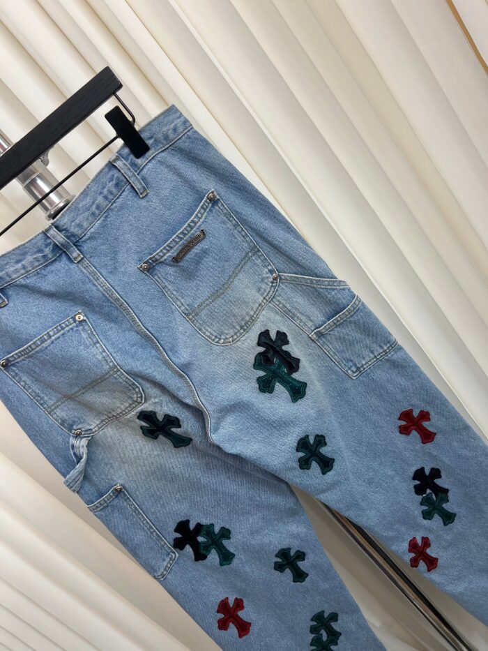 Jeans vintage azzurri con patch a croce colorati, stile casual e urbano, pratici e di tendenza.
