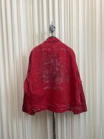 Giacca vintage rossa con grafica sfumata, stile casual e look retrò su sfondo crema.