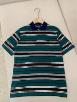Maglietta polo a righe colorate in tessuto leggero, con colletto navy, stile casual e vivace.