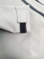 Tessuto impermeabile grigio con chiusura a Velcro, ideale per abbigliamento sportivo e outdoor.