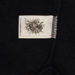 Etichetta moderna con web a ragno su tessuto fleece morbido e di tendenza.