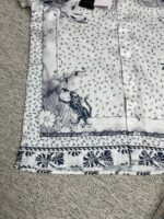 Camicia femminile con gatto, motivi floreali, stile artistico e design casual elegante.
