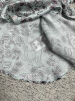 Tessuto pastello con fantasie di fiori e animali, perfetto per abiti e progetti creativi.