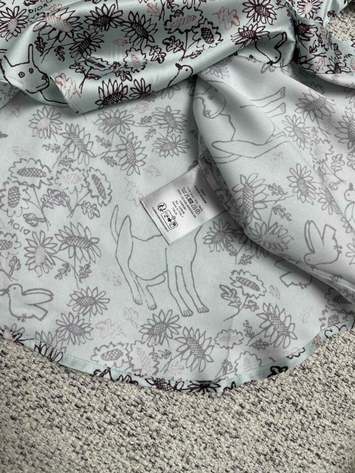 Tessuto pastello con fantasie di fiori e animali, perfetto per abiti e progetti creativi.