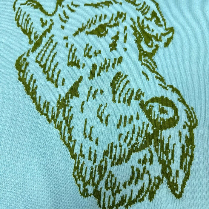 Illustrazione stilizzata di una capra verde su sfondo blu, simbolo di natura e serenità.