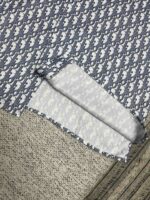 Tessuto blu navy con motivo giocoso, ripiegato su superficie tessile, ideale per craft e cucito.