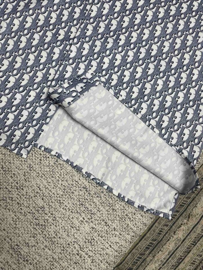 Tessuto blu navy con motivo giocoso, ripiegato su superficie tessile, ideale per craft e cucito.