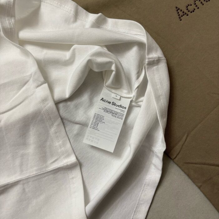 Camicia bianca minimalista Acné Studios su sfondo neutro, elegante e di alta qualità.