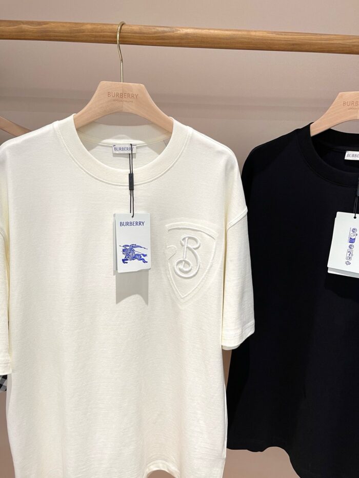 Magliette casual bianca e nera in vetrina, stile moderno e versatile per ogni occasione.