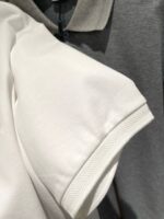 Magliette polo bianche e grigie, stile casual, di alta qualità in esposizione vendita.