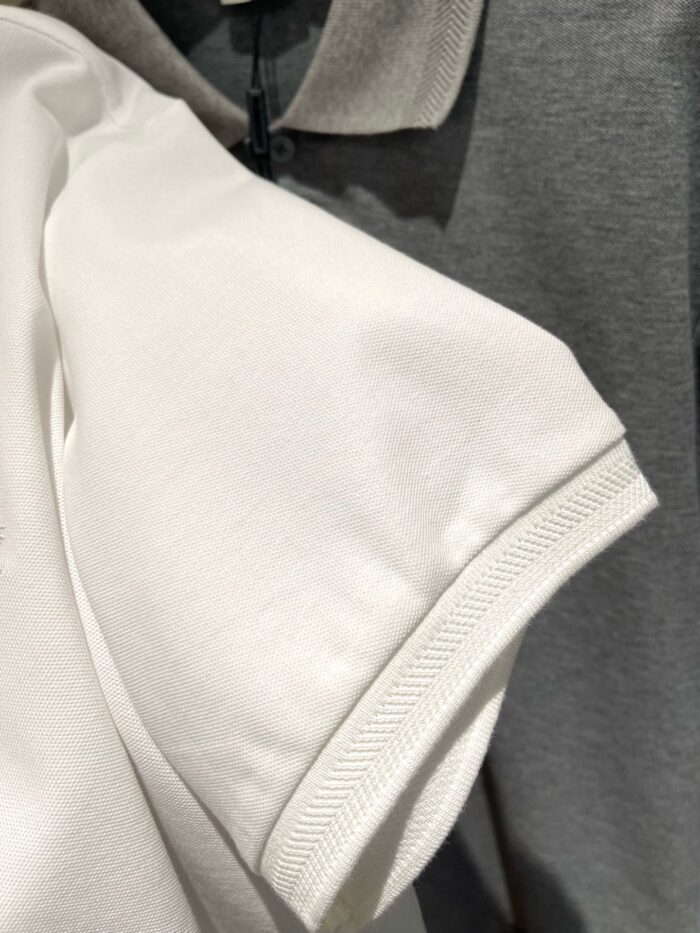 Magliette polo bianche e grigie, stile casual, di alta qualità in esposizione vendita.