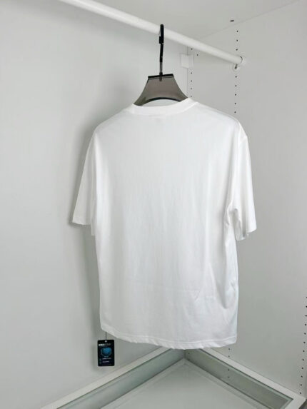 Maglietta bianca semplice con collo rotondo, vista posteriore, ideale per un look casual e versatile.