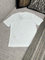 Maglietta bianca semplice su divano grigio, stile casual e comfort quotidiano.
