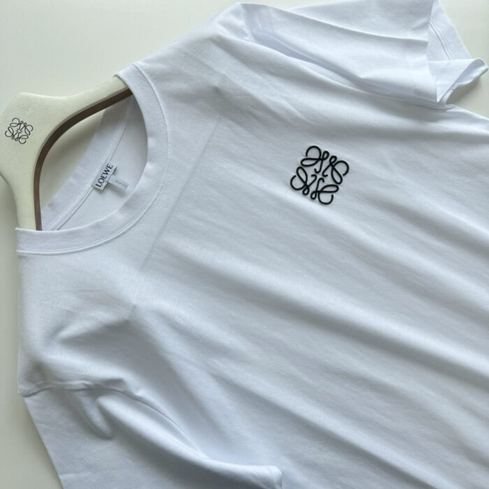 Maglietta bianca minimalista con logo nero elegante, stile casual e facile da abbinare.