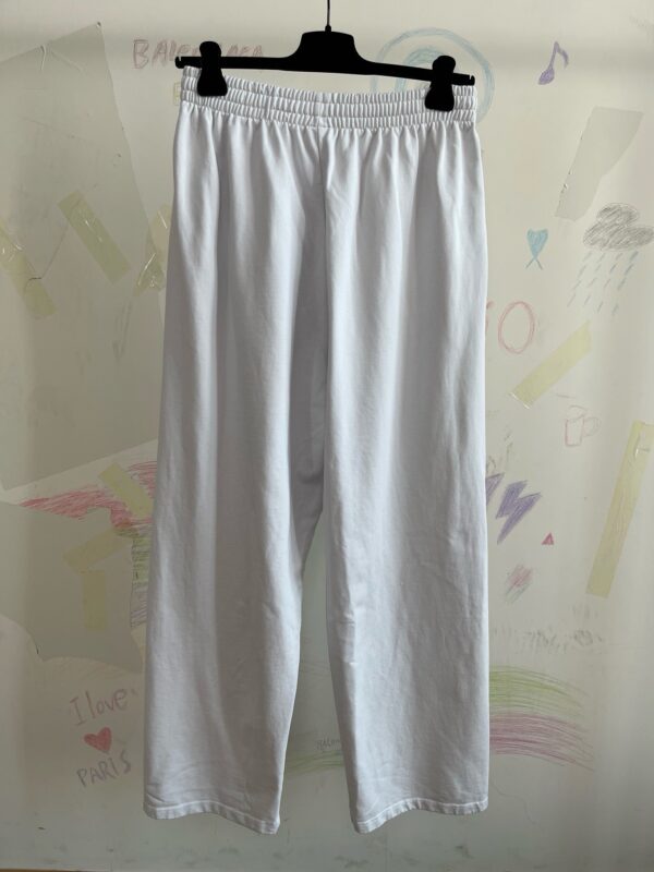 Pantaloni bianchi casual con vita elastica su sfondo colorato e allegro.