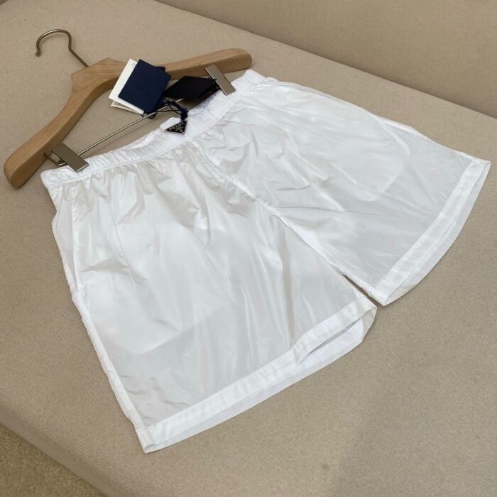 Pantaloncini bianchi casual, leggeri e elasticizzati, ideali per sport e relax, su supporto in legno.