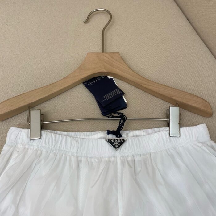 Shorts casuali bianchi nuovi su appendiabiti in legno, comfort e stile autentico.