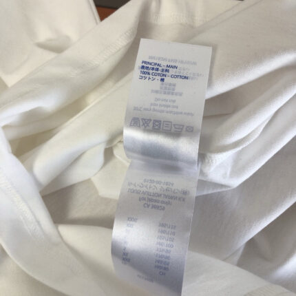 Etichetta di cura su abbigliamento bianco morbido e versatile, attenzione alla lavatrice.