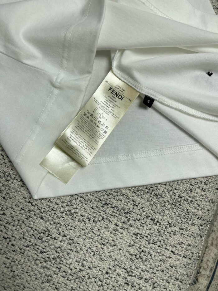Etichetta Fendi su maglietta bianca di lusso, dettaglio moda e cura del capo.