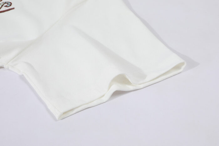Maglietta bianca cotone con manica corta e dettagli di ricamo sottile elegante.
