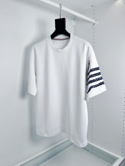 T-shirt bianco casual con dettagli di righe sulla manica, stile semplice e moderno.