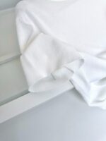 Dettaglio di manica bianca morbida, ideale per look minimalisti e casual.