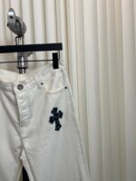 Pantaloni bianchi in denim con ricamo a croce blu navy, stile elegante e versatile.