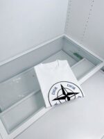 Maglietta bianca Dior con logo grafico, display minimalista e di lusso in vetrina moderna.