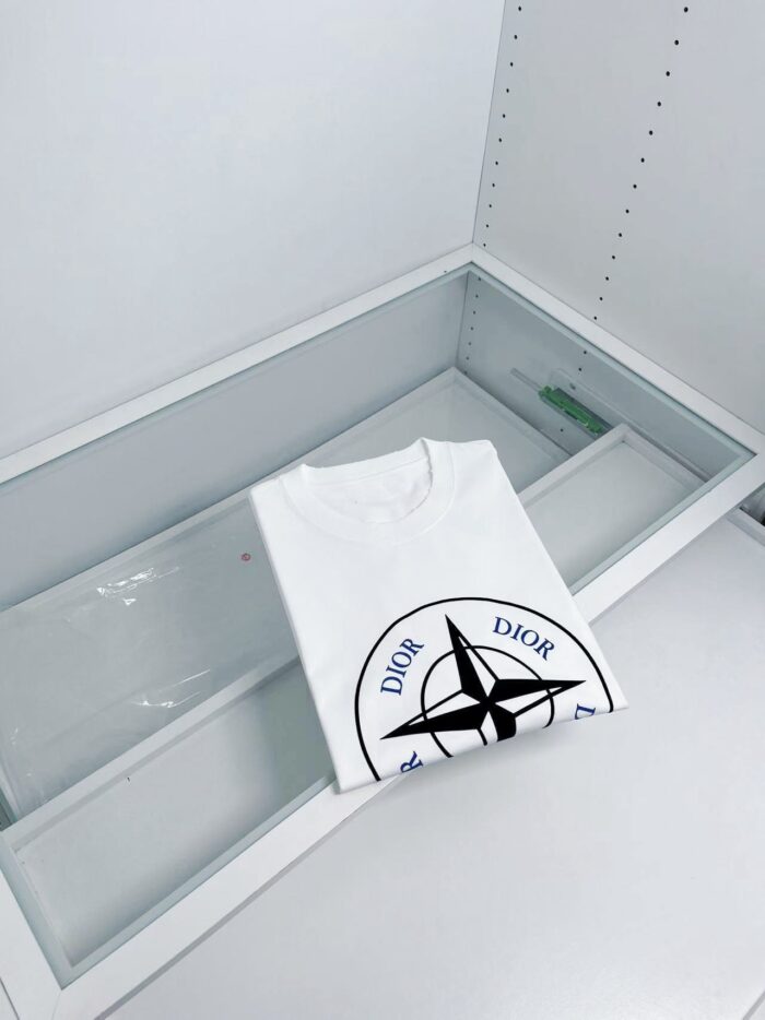 Maglietta bianca Dior con logo grafico, display minimalista e di lusso in vetrina moderna.