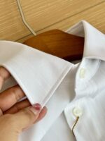 Camicia bianca elegante con collo a punta e dettagli di cuciture impeccabili.