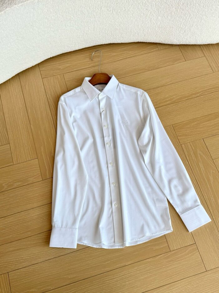 Camicia bianca elegante su pavimento in parquet a spina di pesce, stile classico e versatile.