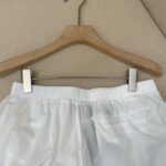Pantaloncini bianchi casual con elastico in vita e tasca posteriore, ideali per lestate.