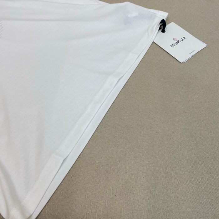 Top bianco in cotone con etichetta, drappeggio elegante e stile versatile.