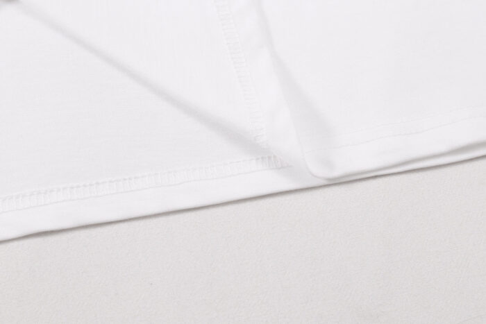 Tessuto bianco morbido con cuciture precise, ideale per abbigliamento elegante e versatile.