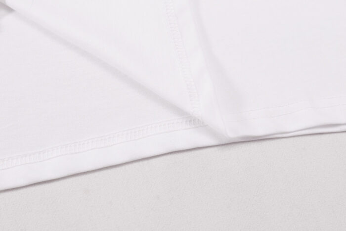 Dettaglio di tessuto bianco morbido con cuciture precise, stile minimalista e qualità superiore.