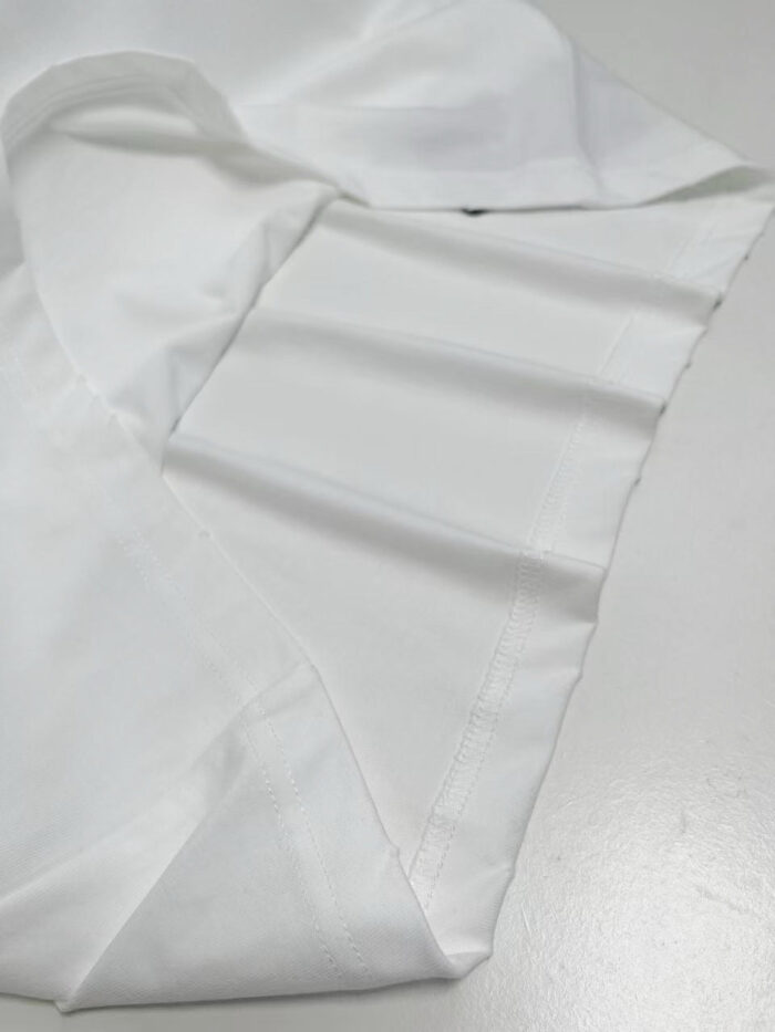Tessuto bianco di alta qualità, con cuciture precise e aspetto elegante per moda e arredamento.