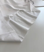 Tessuto bianco di alta qualità con cuciture precise e morbida texture elegante.