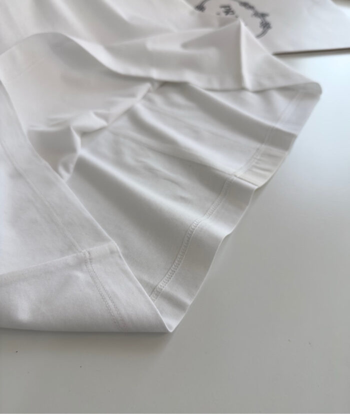 Tessuto bianco di alta qualità con cuciture precise e morbida texture elegante.