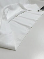 Tessuto bianco elegante con cuciture sottili e tasca con cordino, ideale per abbigliamento raffinato.