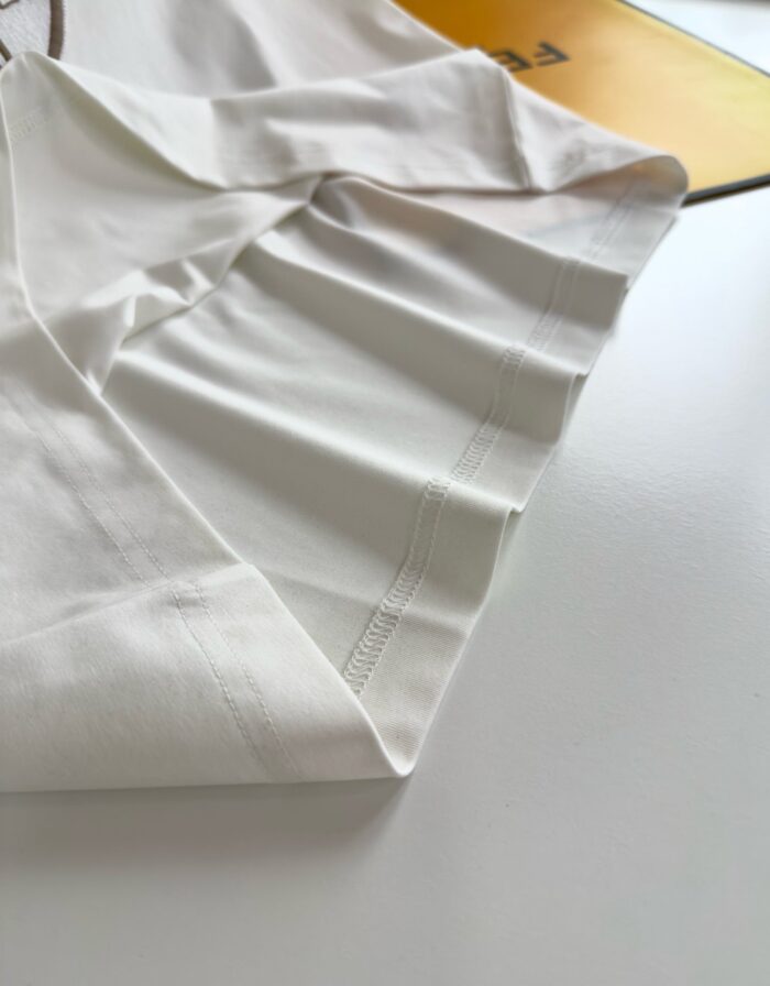 Camicia bianca elegante appesa su supporto con dettagli di cucitura e finiture di qualità.
