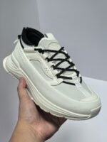 Scarpa sneakers bianca futuristica con lacci neri, suola imbottita e grip antiscivolo elegante.