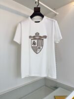 Maglietta bianca con emblem heraldico elegante e stile casual, ideale per ogni occasione.