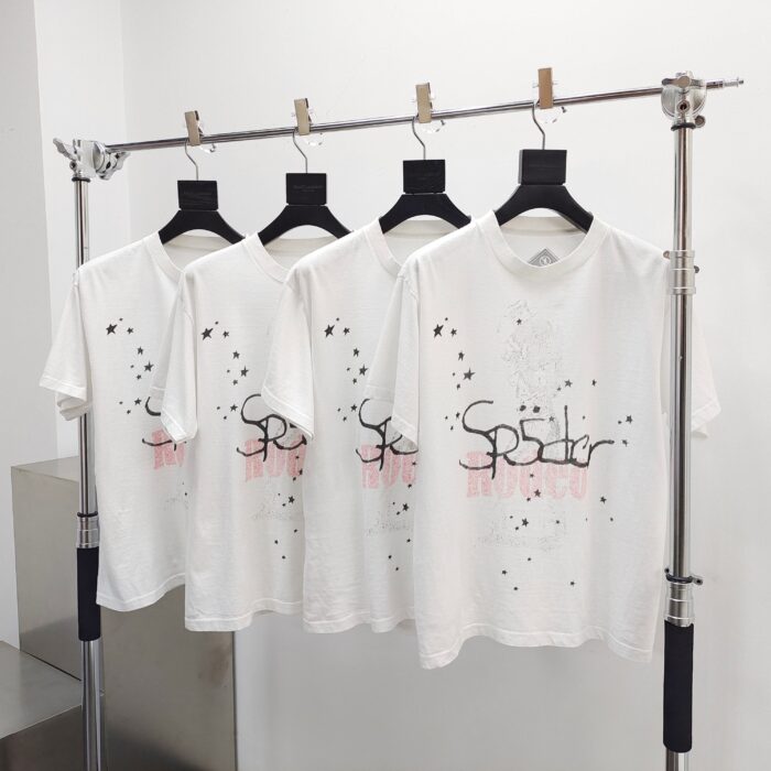 T-shirt bianche con grafica artistica e schizzi di colore, setup minimalista e moderno.