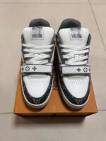 Sneakers di lusso bianche e grigie su scatola di legno, stile streetwear elegante.