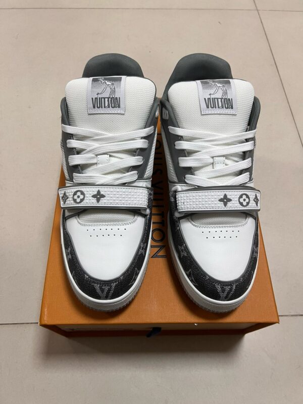 Sneakers di lusso bianche e grigie su scatola di legno, stile streetwear elegante.