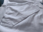 Maglietta bianca casual con tasche laterali in cotone, design minimalista e comfort elevato.