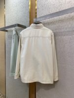 Giacca bianca minimalista in negozio, versatile ed elegante, perfetta per ogni occasione.
