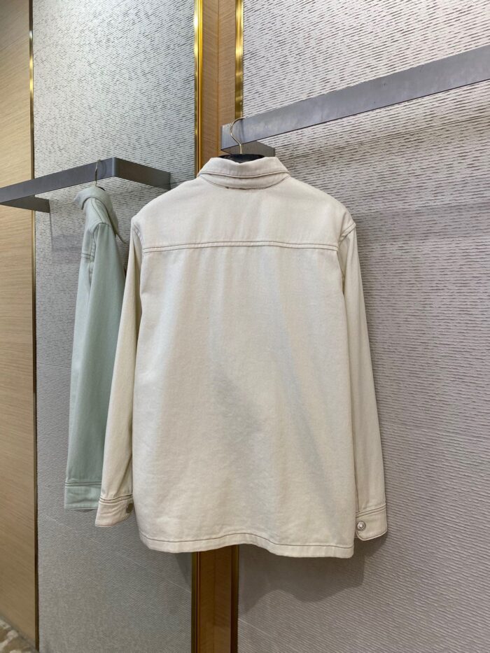 Giacca bianca minimalista in negozio, versatile ed elegante, perfetta per ogni occasione.
