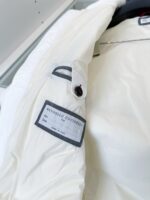 Giacca bianca elegante con dettagli moderni, etichetta minimal e bottoni eleganti.